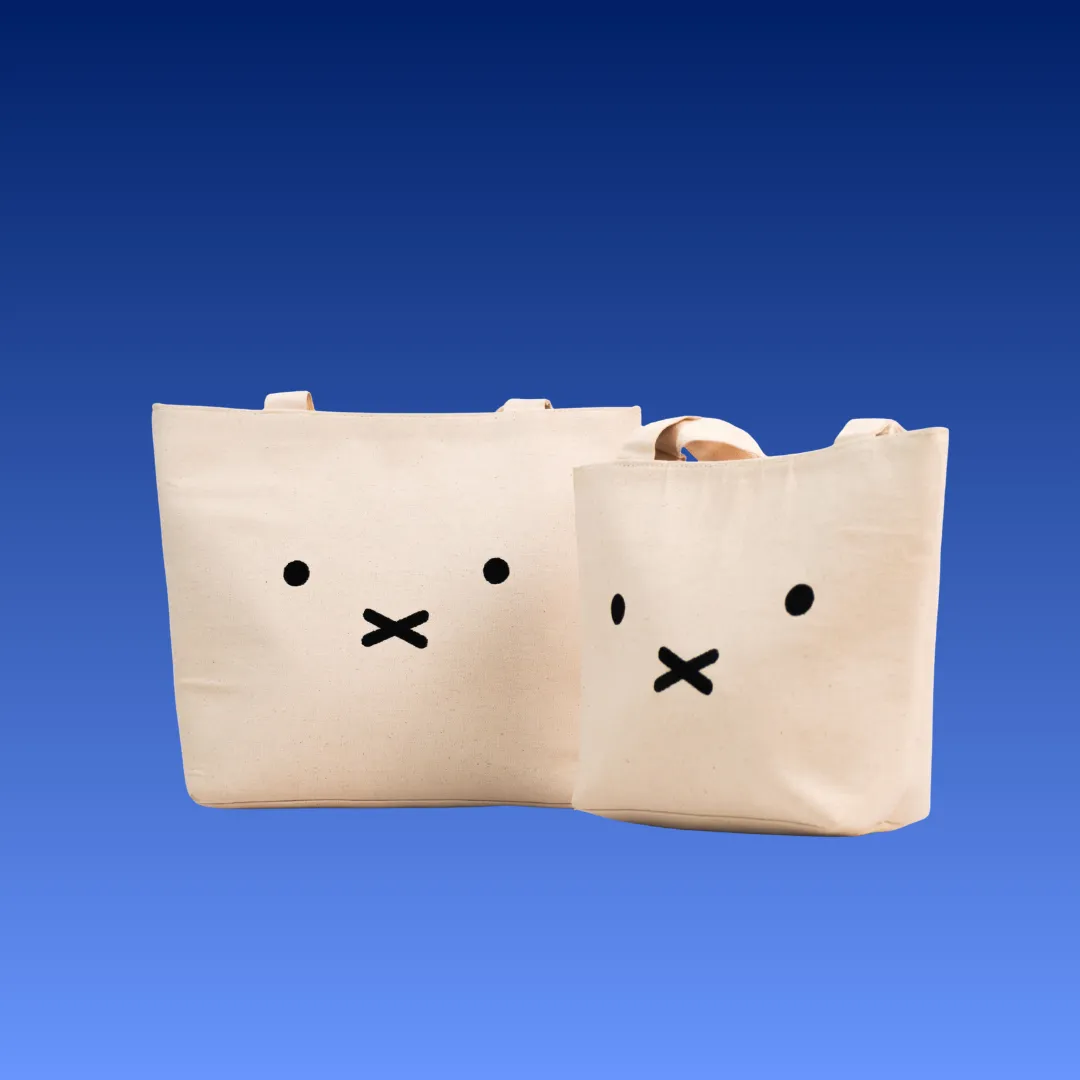 Dua tote bag kanvas dengan sablon karakter, ukuran besar dan kecil.